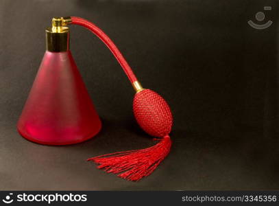 red cologne spray on a black background