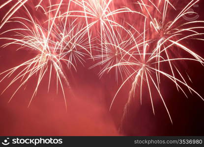 Red colorful fireworks on the black sky background. Holiday celebration.