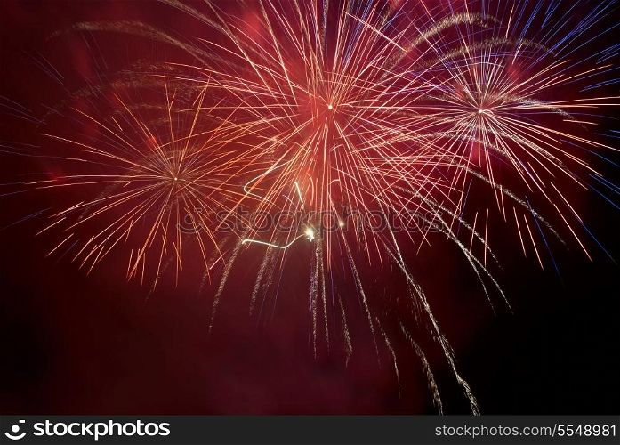 Red colorful fireworks on the black sky background. Holiday celebration.