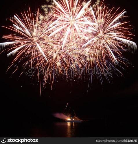 Red colorful holiday fireworks on the black sky background.