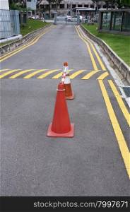 Red cones and yellow striped warning road
