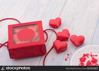 Red cookies in the shape of a heart in a gift box on wooden boards and a plate and decorated with ribbon on Valentine&rsquo;s Day. cookies in the shape of hearts on Valentine&rsquo;s Day