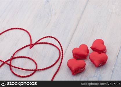 Red cookies in the shape of a heart on a wooden board and decorated with ribbon on Valentine&rsquo;s Day. cookies in the shape of hearts on Valentine&rsquo;s Day