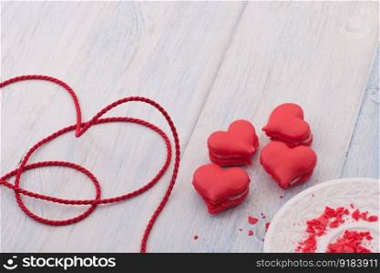 Red cookies in the shape of a heart on wooden boards and a plate and decorated with ribbon on Valentine&rsquo;s Day. cookies in the shape of hearts on Valentine&rsquo;s Day