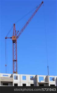 red crane and blue sky on building site