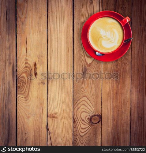 red cup and latte coffee on wood table with space.