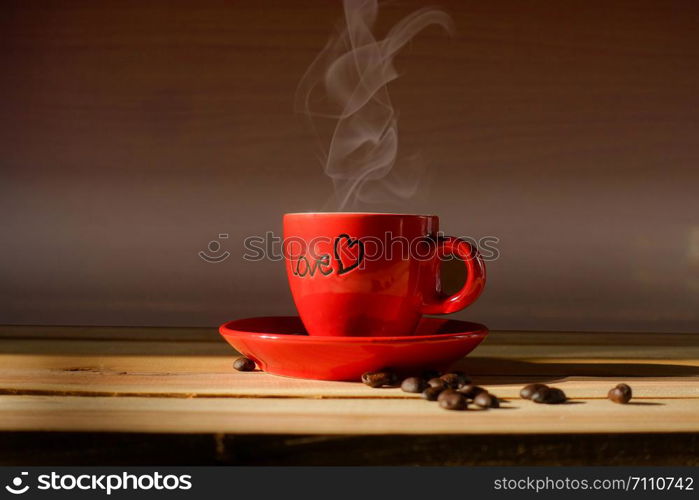 Red cup coffee on wooden with coffee beans, Light and shadow style.