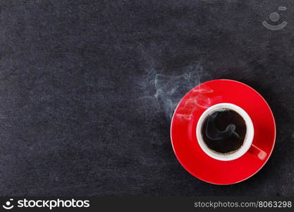 Red cup of coffee with smoke on black background. Red cup of coffee with smoke