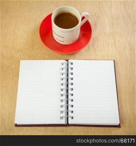 red cup of hot coffee and book on wood background