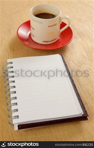 red cup of hot coffee and book on wood background
