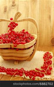 red currant on the wooden vase. clusters of fresh ripe berries of red currant on the wooden vase