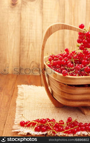 red currant on the wooden vase. clusters of fresh ripe berries of red currant on the wooden vase