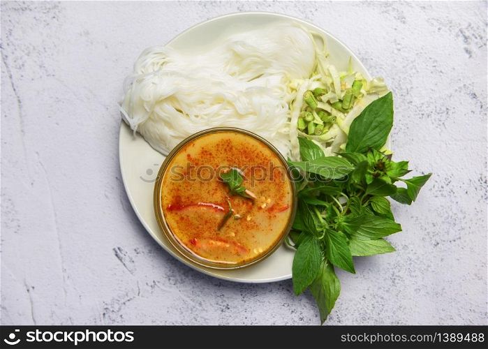 Red curry cuisine asian food on the table / Thai food curry soup bowl with thai rice noodles ingredient herb vegetable on white plate