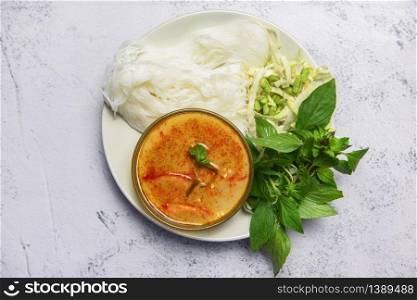 Red curry cuisine asian food on the table / Thai food curry soup bowl with thai rice noodles ingredient herb vegetable on white plate