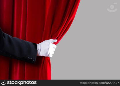 Red curtain. Close up of hand in white glove open the curtain. Place for text