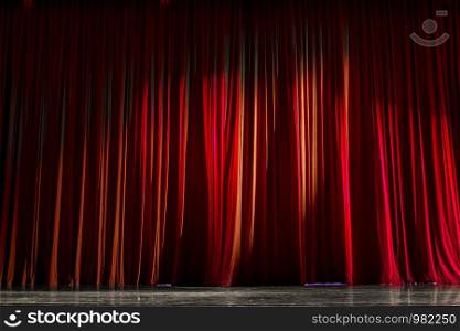 Red curtains and the wooden stage in a theater.