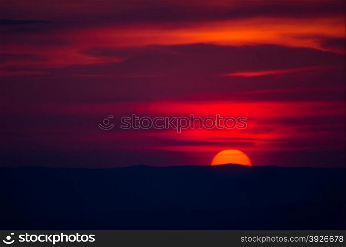 red disk of the sun goes below the horizon