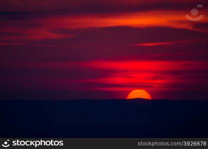 red disk of the sun goes below the horizon