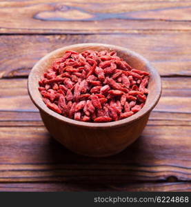 Red dried goji berries in a wooden bowl. The Goji berries