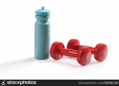 Red dumbbells and water bottle isolated over white background