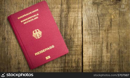 Red European Passport on wood texctured background.