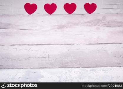 Red felt hearts on a background of old wooden planks resembling an old parquet floor. Concept of valentines day and love in general.. Red felt hearts on a background of old wooden planks resembling an old parquet floor. Concept of valentines day and love in general