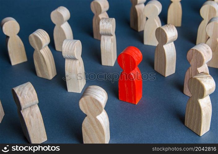 Red figurine of a man in a crowd of people. Stranger, eye-catching. Different, special. Infected carrying threat of spread of a pandemic. Collective immunity. Social distance. Intruder detection