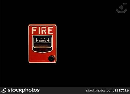 red fire alarm box on black background