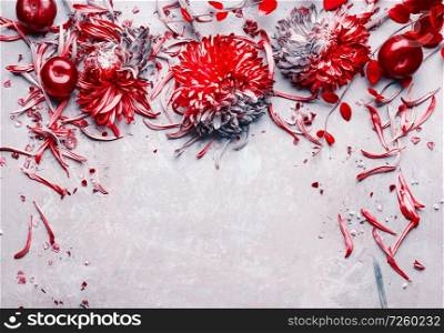 Red flowers and fruits border on light gray background, top view, frame. Floral layout, flat lay with copy space for your design