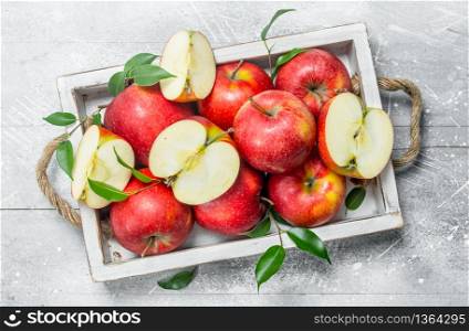 Red fresh apples in a wooden box. On rustic background.. Red fresh apples in a wooden box.