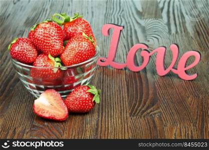 Red fresh strawberry in a bowl on brown wooden background. Strawberry in a bowl on brown wooden background