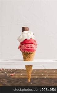 red frozen ice scoop with with whipped cream chocolate cone