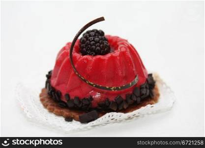 red fruitcake with chocolate and bramble decoration