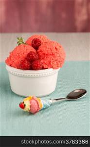 Red fruits ice cream and spoon on table backrground