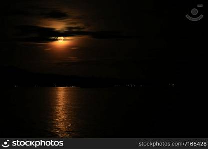 Red full moon sunset and reflection In Raja Ampat, West Papua, Indonesia
