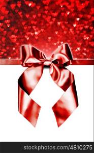 Red gift bow on white. Red gift ribbon bow and heart bokeh isolated on white background
