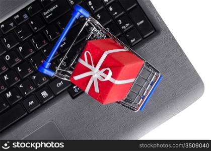 red gift box in shopping cart on a laptop keyboard