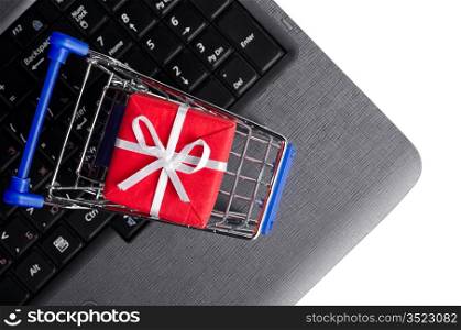 red gift box in shopping cart on a laptop keyboard