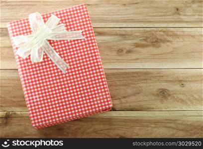 Red gift box on the wooden floor.. Red gift box on the wooden floor in concept of Christmas and New Year.