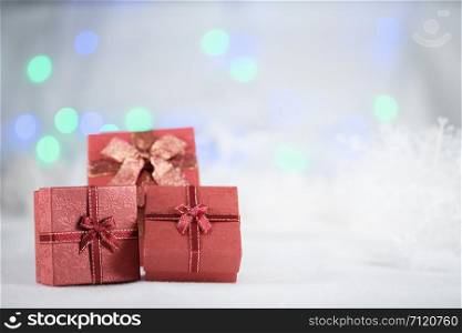 Red gift boxes on the white fur on bokeh background, with copy space for season greeting. Merry Christmas or Happy New Year.AF point selection,blurred