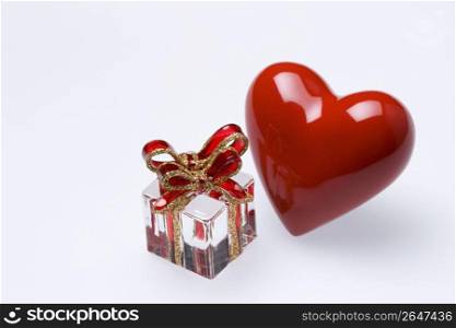 Red glass heart and glass present isolated on a white background