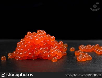 red grainy chum salmon caviar on black background, close up