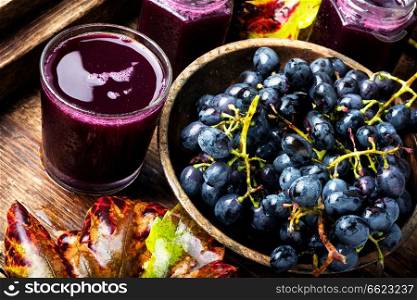 Red grape juice in glass and grape fruit.Rustic style. Red grape juice in glass
