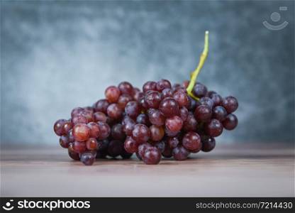 Red grape on wooden table / Bunch of grapes juicy fruit on light and dark background