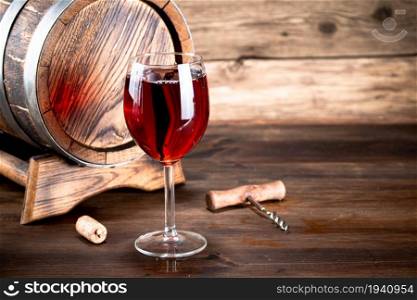 Red grape wine in a glass. On a wooden background. . Red grape wine in a glass.