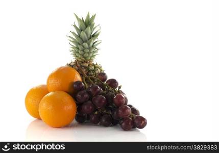 red grapes oranges and pineapple fruit isolated on white