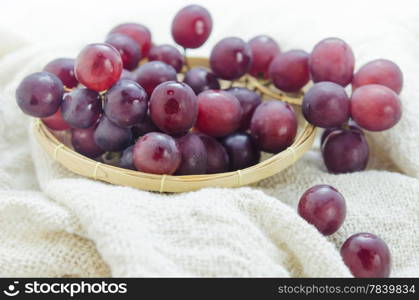 red grapes. red grape in wooden basket over sackcloth