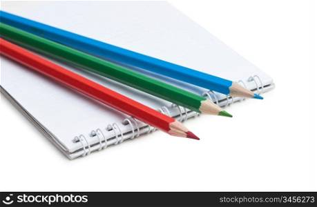red green blue pencils and notebook isolated on a white background