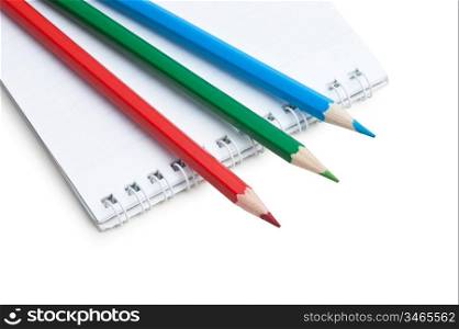 red green blue pencils and notebook isolated on a white background