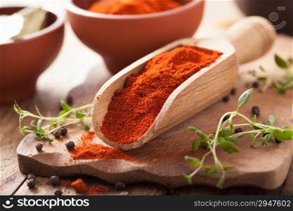 red ground paprika spice in wooden scoop and bowl